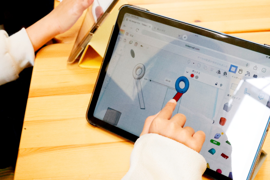 STEAM教育の授業で小学生がタブレットを使い、Tinkercadで文房具をテーマにした3Dモデリングを体験中。