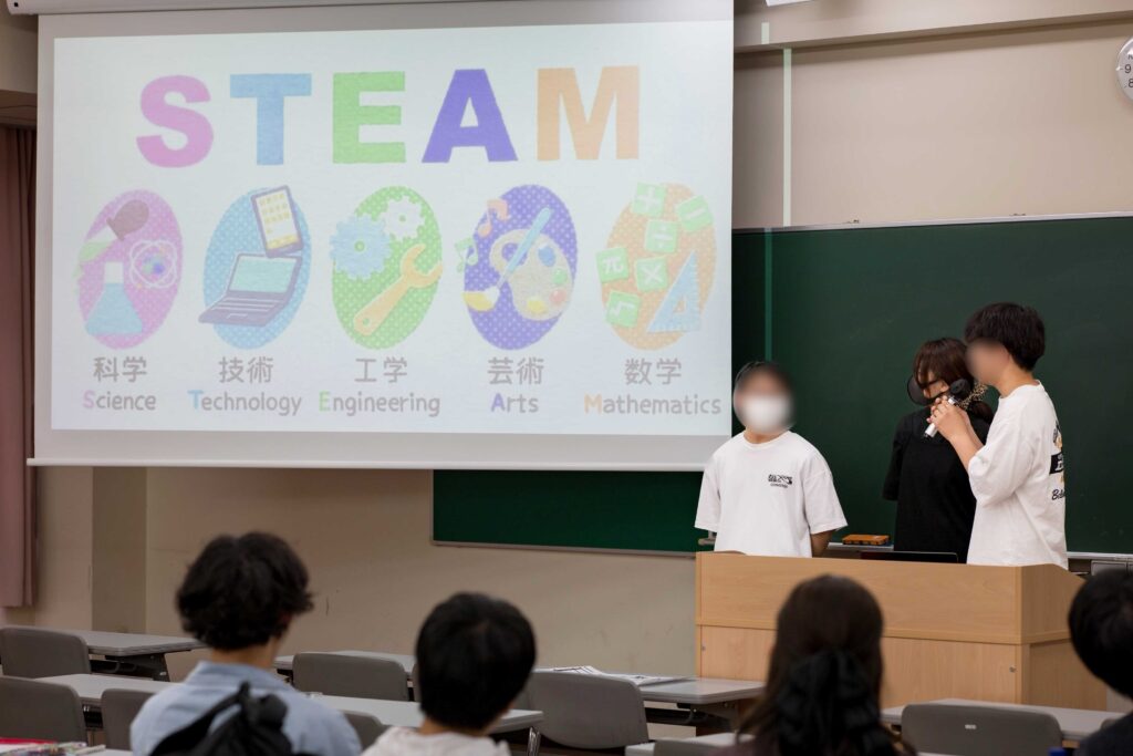 白梅学園大学で行われたSTEAM教育の授業にて、学生が「科学・技術・工学・芸術・数学」の要素を紹介するプレゼンテーションを行う様子