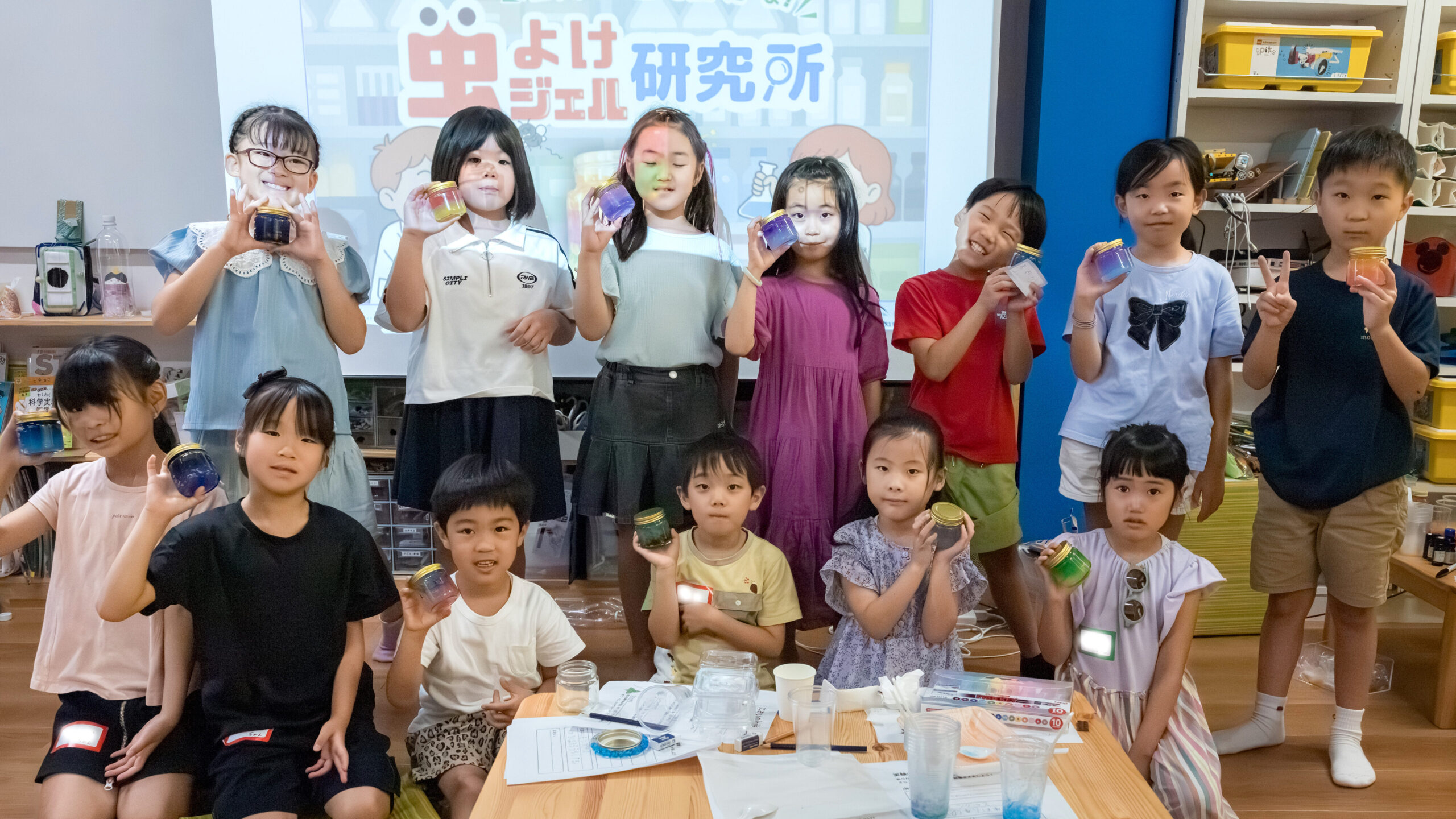 小学生が作った虫よけジェルを手に笑顔で集合写真｜夏の科学ワークショップの様子