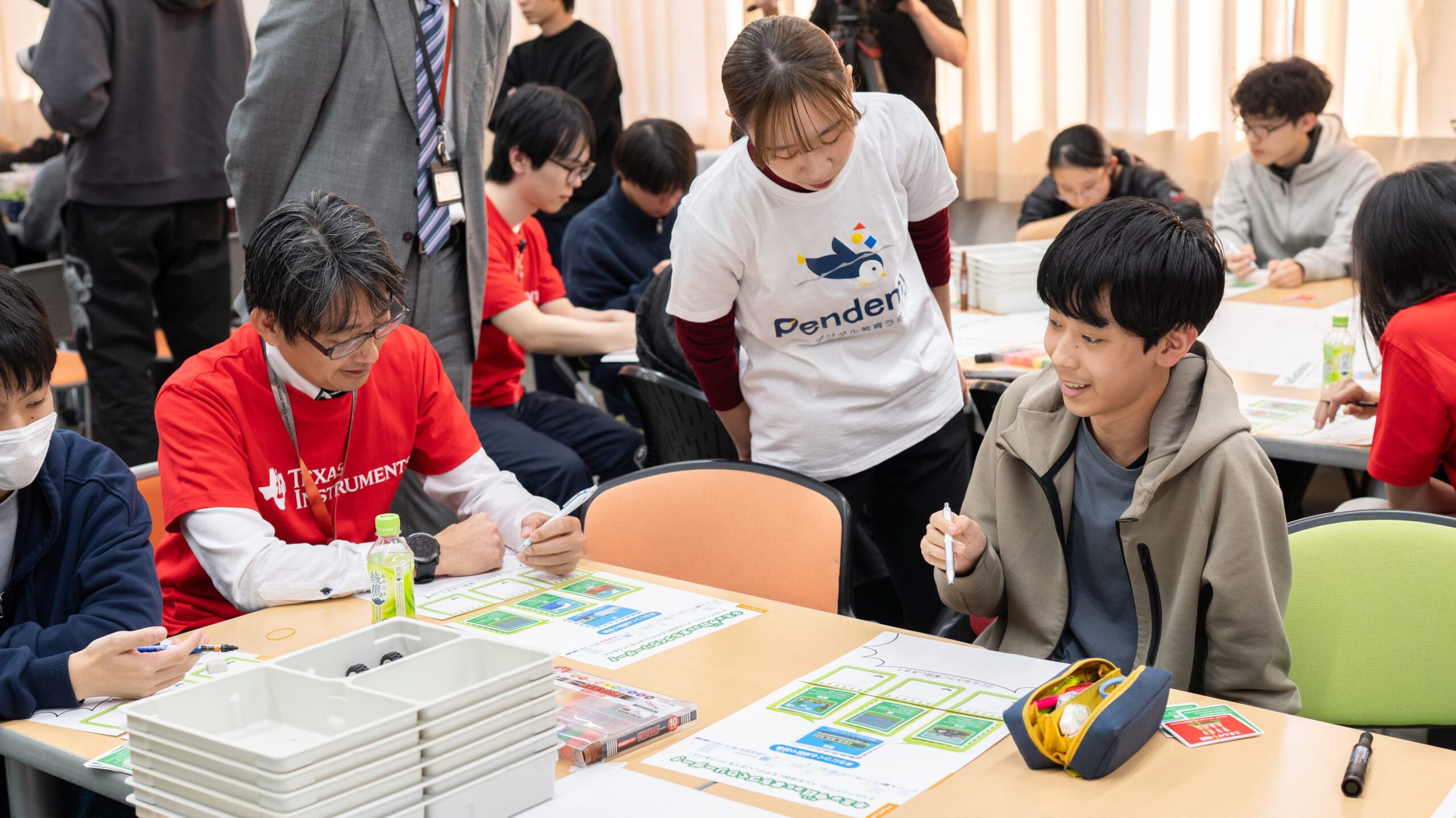 テキサス・インスツルメンツ社員と高専生が都市計画ワークショップでサステナカードを使い未来の品川の施設を考える様子。Pendemyが学びをサポート。