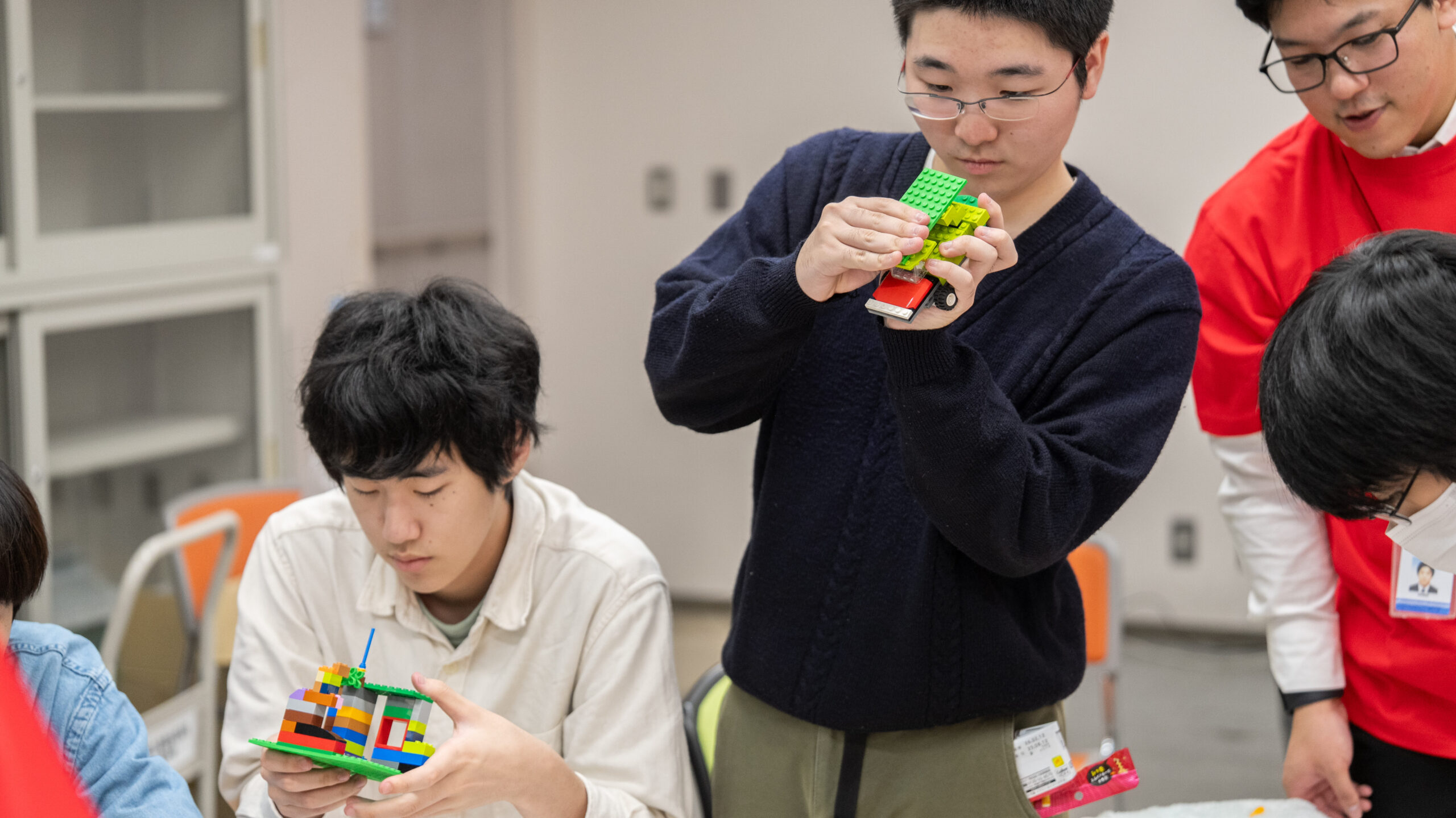 高専生がレゴでサステナブルな未来施設を制作する様子。テキサス・インスツルメンツ社員が参加する都市計画ワークショップでのレゴ制作シーン。