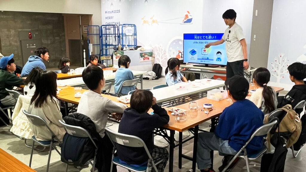 Pendemyの光ファイバーツリー作りイベント(ミッテン府中)で、子どもたちが光の進み方・通信の仕組みを学ぶ講義シーン