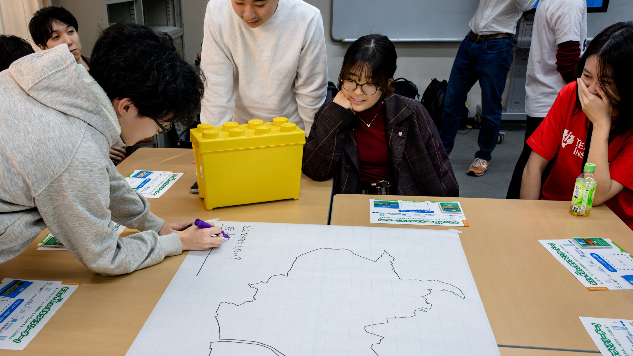 高専生が白地図に未来の品川のテーマを書き込み、都市計画のアイデアを共有する様子。サステナブルな街づくりワークショップのミッション0の風景。
