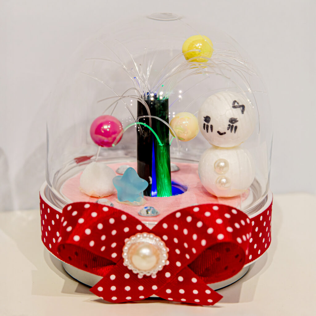 光ファイバーツリーの完成作品。ドームの中でLEDが光り、雪だるまやリボンでデコレーションしたオリジナル工作(Pendemyがミッテン府中で開催)