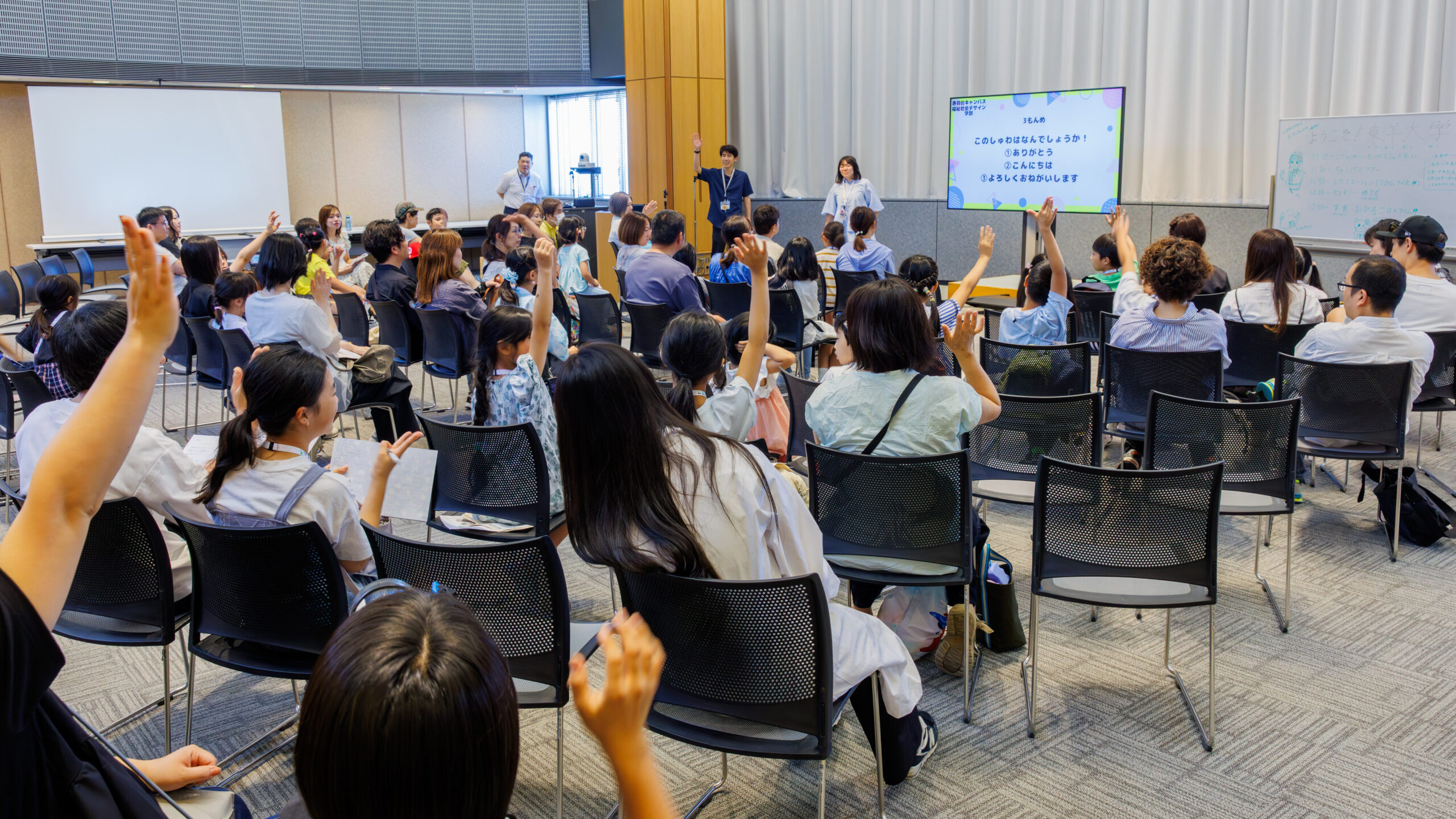 東洋大学オープンキャンパスでSDGsクイズに挙手して参加する小学生と保護者
