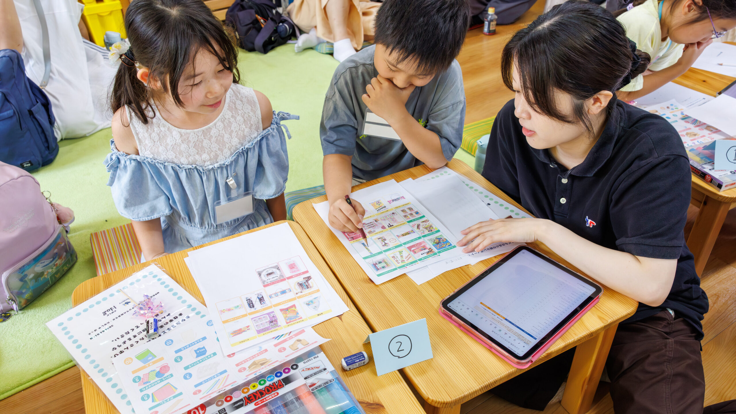 子ども店長プロジェクトで販売する商品を選びスタッフと一緒に計画する小学生