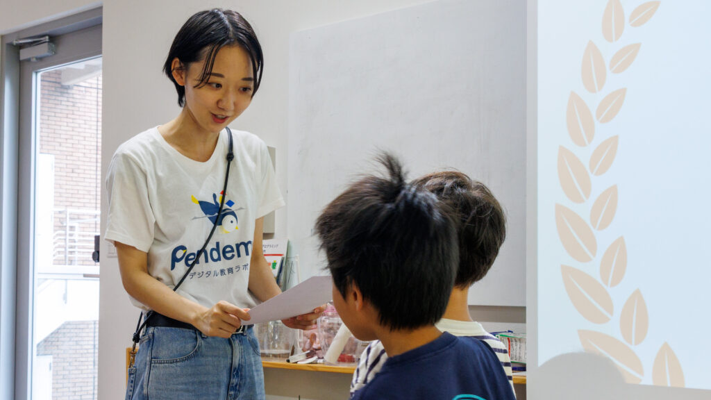 表彰式で優勝したグループの子どもたちに賞状を手渡すスタッフ